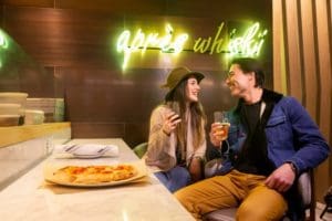 A couple enjoying pizza and a drink