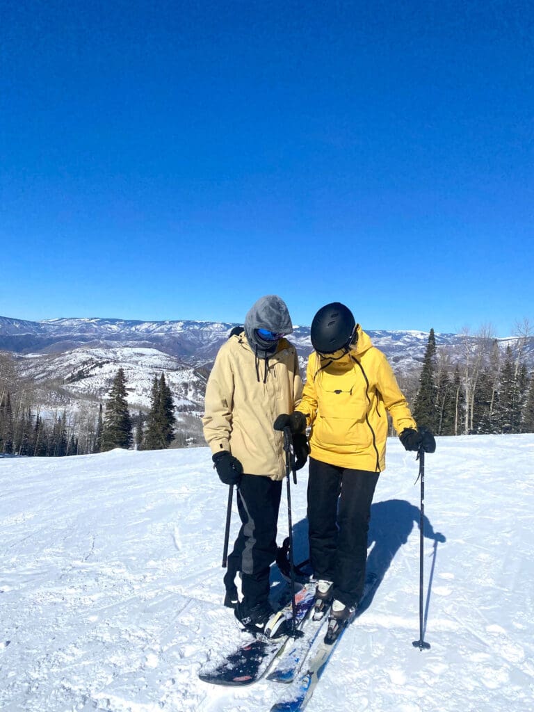 a couple snowboarding and skiing in snowmass village colorado